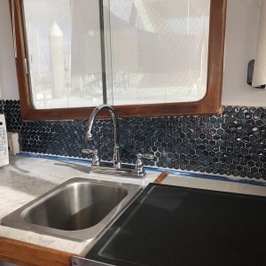 new faucet, tile backsplash and custom cutting board for stove top in Galley